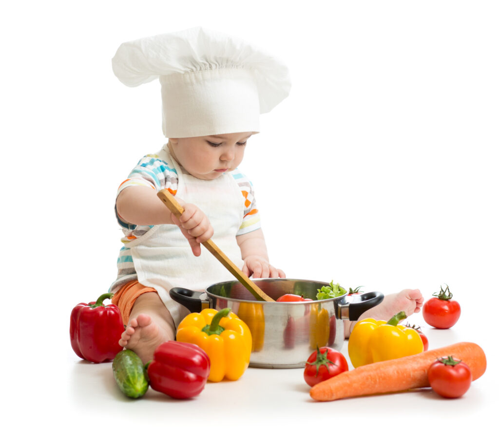baby chef with healthy food vegetables and pan, isolated on white